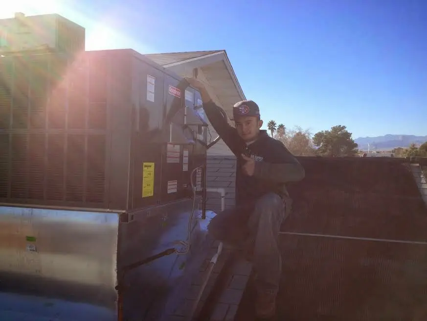 HVAC technician performing HVAC Inspection on a rooftop unit in Hopkinton